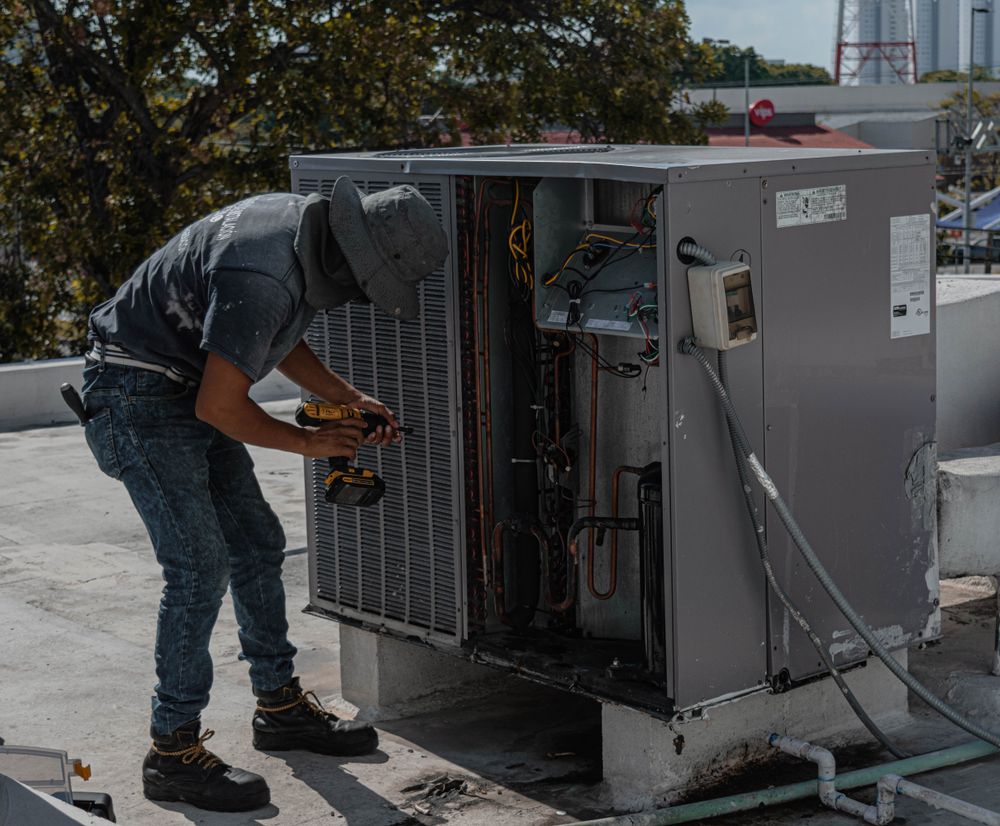 HVAC technician working inside a rooftop unit